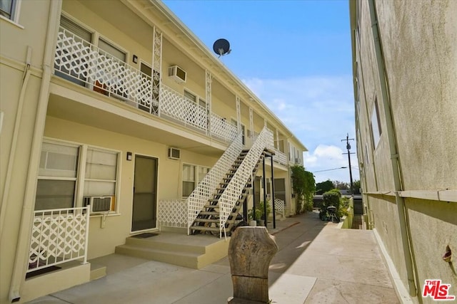 view of property with an AC wall unit and cooling unit