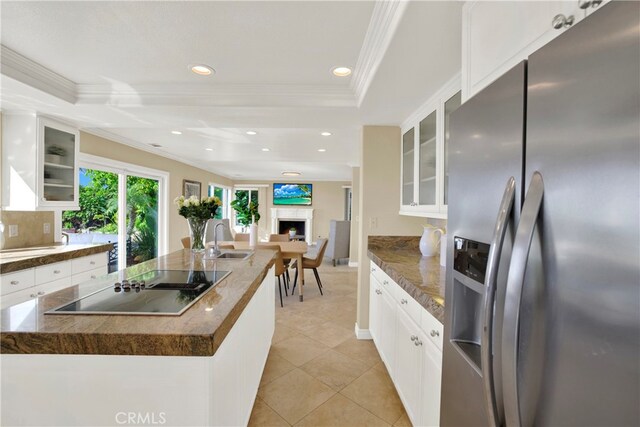 kitchen featuring a tray ceiling, black electric stovetop, ornamental molding, a sink, and stainless steel fridge with ice dispenser