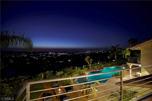 pool at twilight featuring a patio area and an outdoor pool