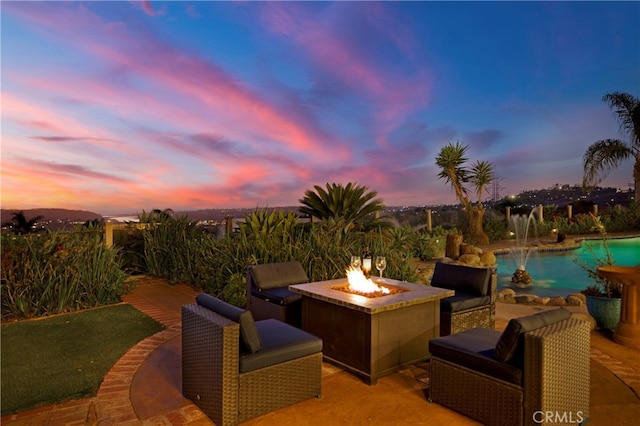 view of patio featuring an outdoor pool and a fire pit