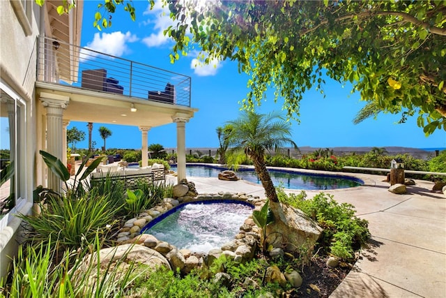 pool featuring a patio area and an in ground hot tub