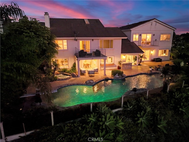 pool at dusk with a hot tub, a patio area, an outdoor pool, and an outdoor living space