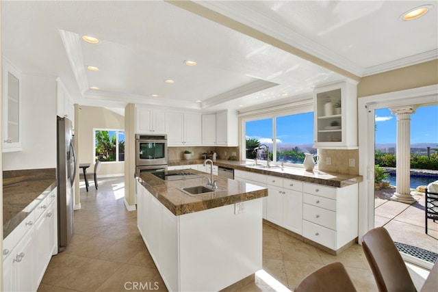 kitchen featuring a sink, plenty of natural light, a raised ceiling, and ornate columns