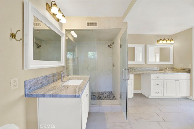 bathroom featuring marble finish floor, two vanities, a sink, and a shower stall