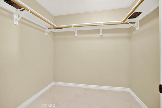 walk in closet with marble finish floor