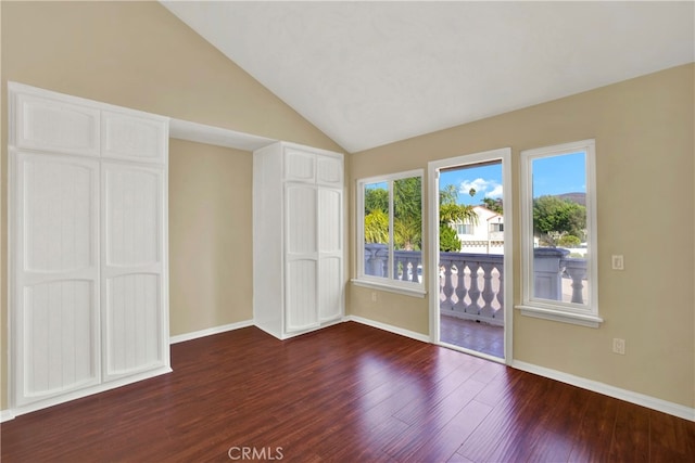 unfurnished bedroom featuring lofted ceiling, access to outside, baseboards, and dark wood-type flooring