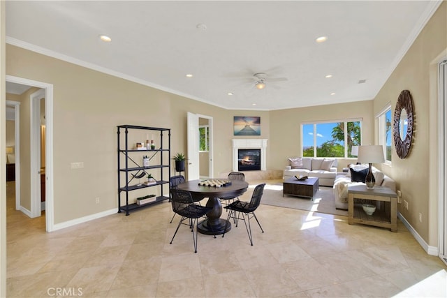 dining room featuring crown molding, recessed lighting, a premium fireplace, ceiling fan, and baseboards