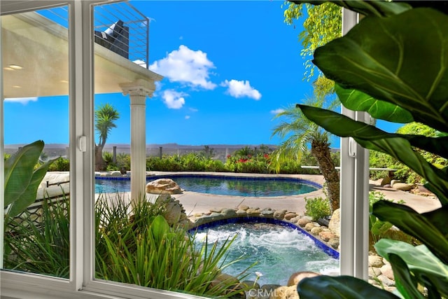 view of swimming pool featuring a fenced in pool and an in ground hot tub