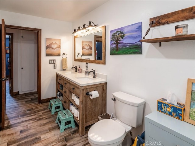 bathroom with vanity, toilet, and wood-type flooring