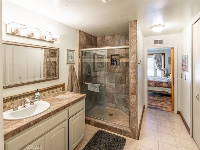 bathroom featuring tile patterned flooring, vanity, and an enclosed shower