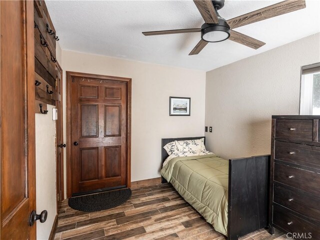 bedroom with dark hardwood / wood-style floors and ceiling fan