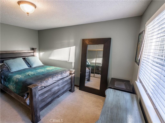 bedroom with light carpet and a textured ceiling