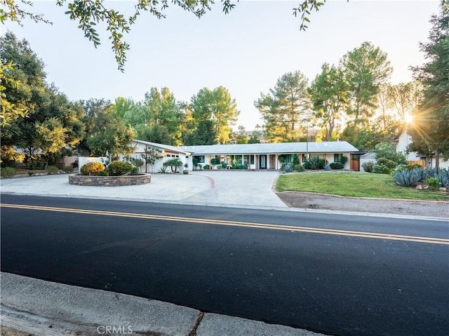 exterior space with concrete driveway and a yard