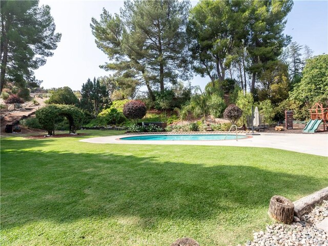 view of pool with a lawn