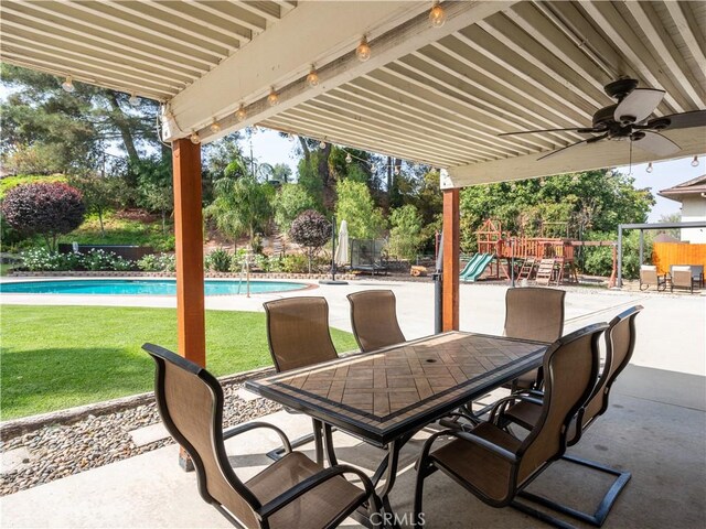 view of patio with a fenced in pool, ceiling fan, and a playground