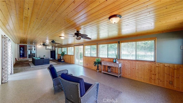 living room featuring plenty of natural light, wooden ceiling, and wooden walls