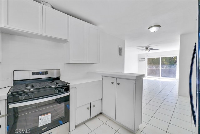 kitchen with stainless steel gas stove, kitchen peninsula, white cabinetry, ceiling fan, and light tile patterned floors