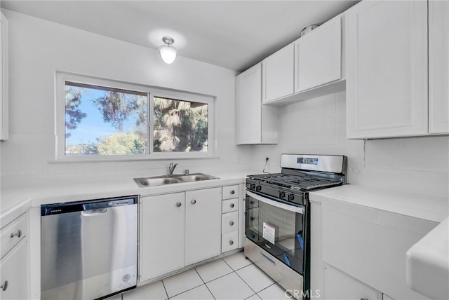 kitchen featuring sink, appliances with stainless steel finishes, white cabinetry, and light tile patterned floors