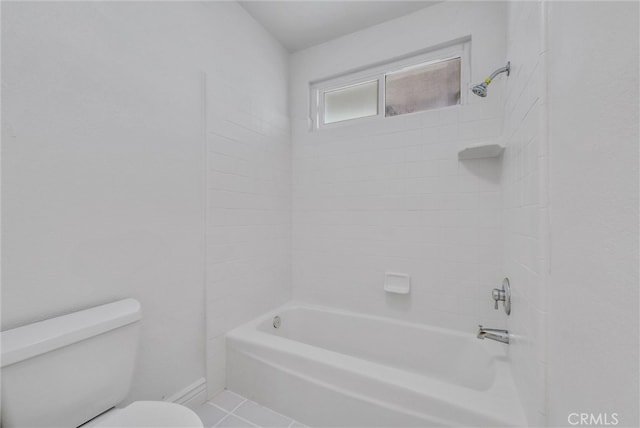 bathroom with tiled shower / bath, toilet, and tile patterned flooring