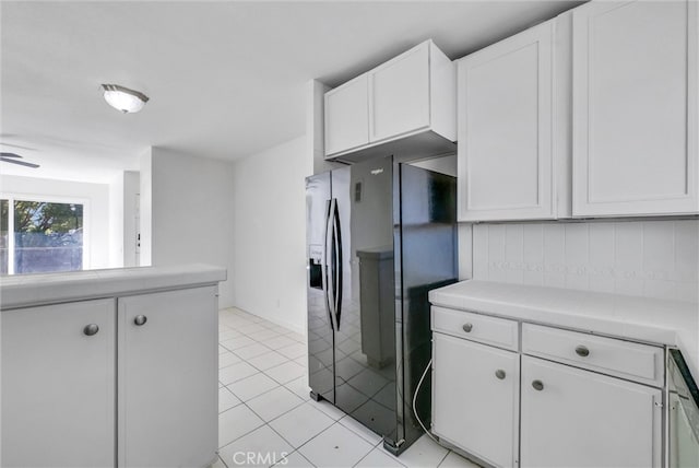 kitchen with tile countertops, backsplash, light tile patterned flooring, white cabinetry, and ceiling fan