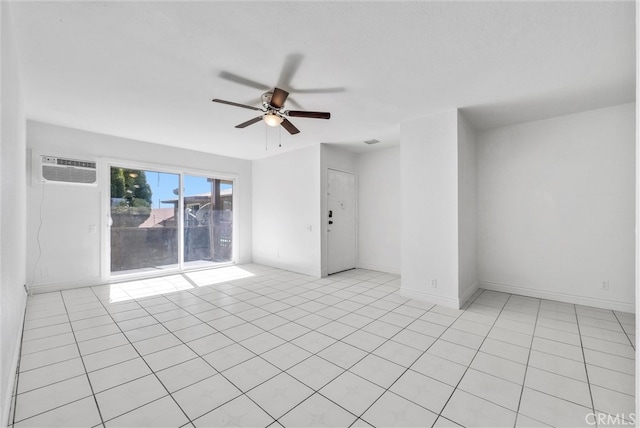 tiled empty room featuring a wall mounted air conditioner and ceiling fan