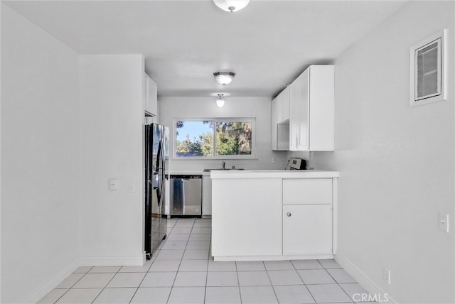 kitchen with appliances with stainless steel finishes, white cabinets, sink, and light tile patterned floors