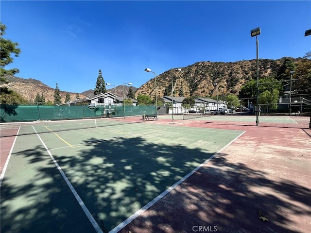 view of tennis court featuring a mountain view