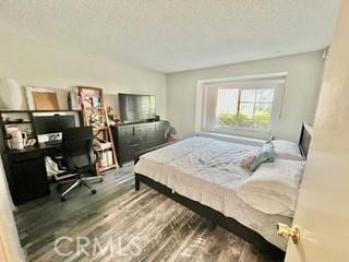 bedroom with hardwood / wood-style floors and a textured ceiling