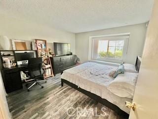 bedroom with hardwood / wood-style floors and a textured ceiling