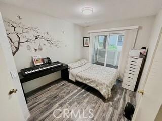 bedroom with access to exterior and dark wood-type flooring