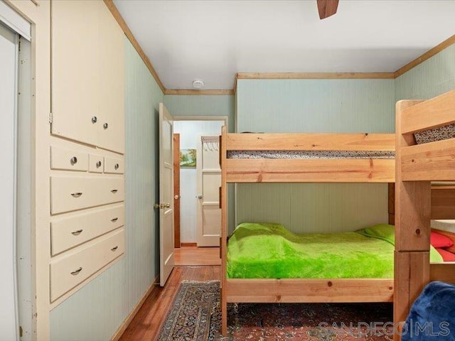 bedroom with wood-type flooring, ceiling fan, and crown molding