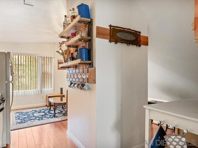 hall with hardwood / wood-style flooring and vaulted ceiling