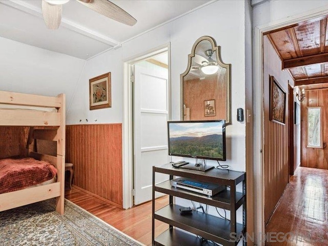 bedroom featuring wood walls, vaulted ceiling, and hardwood / wood-style flooring