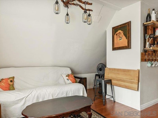 living area with lofted ceiling with beams and wood-type flooring