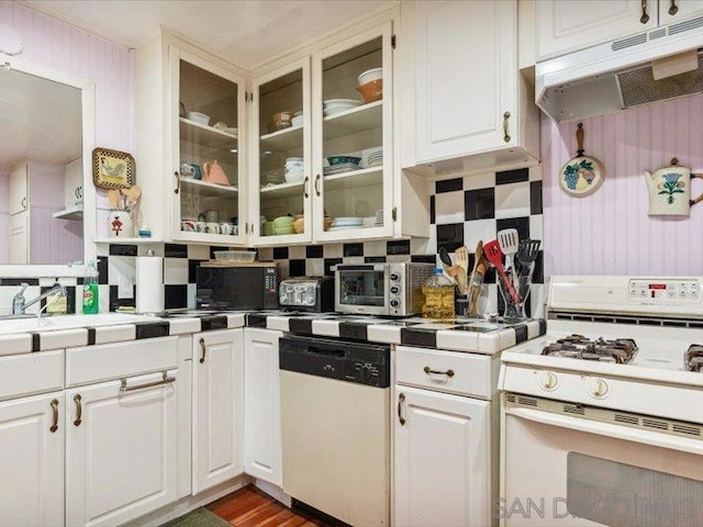 kitchen with white cabinets, white appliances, and backsplash