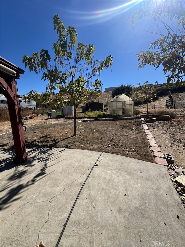 view of yard with a patio and a storage unit
