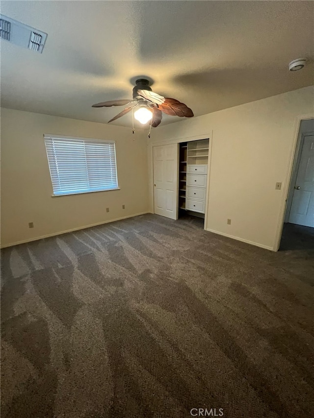 unfurnished bedroom featuring a closet, ceiling fan, and dark carpet