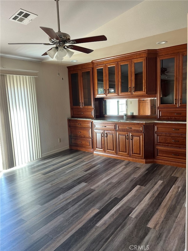 bar with ceiling fan and dark hardwood / wood-style flooring