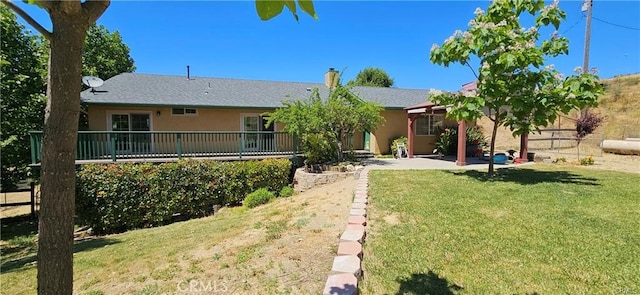 rear view of property featuring a lawn