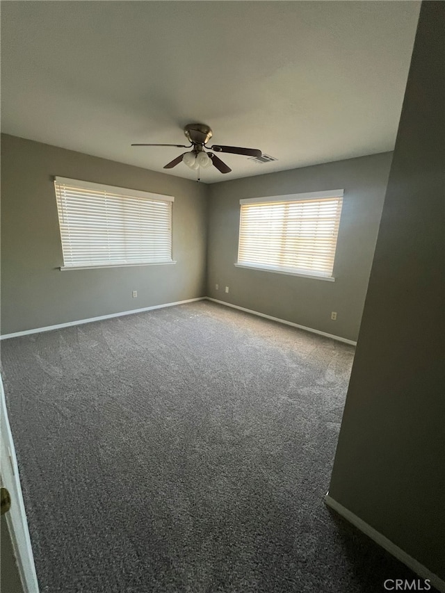carpeted spare room featuring ceiling fan