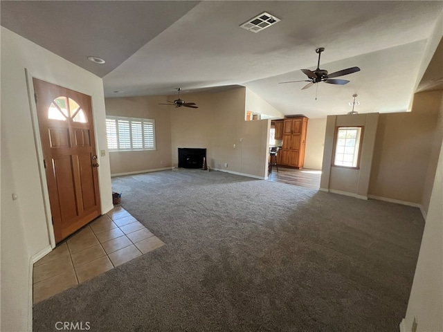 unfurnished living room with vaulted ceiling, light carpet, and ceiling fan