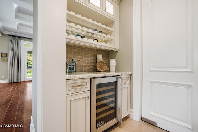 bar featuring ornamental molding, decorative backsplash, wine cooler, and light stone counters