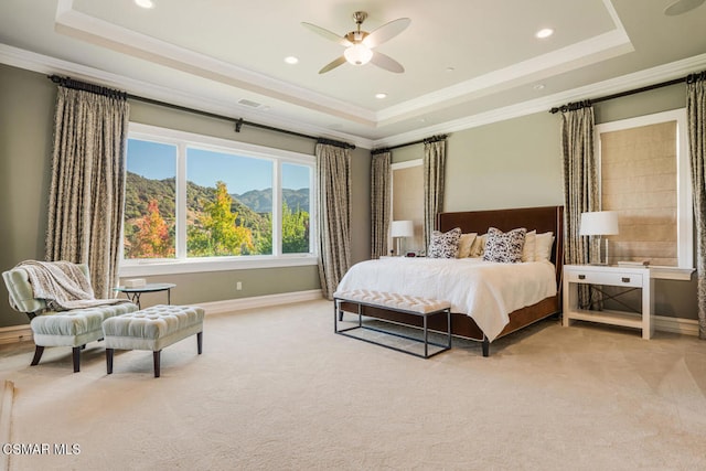 carpeted bedroom with ceiling fan, crown molding, a mountain view, and a tray ceiling