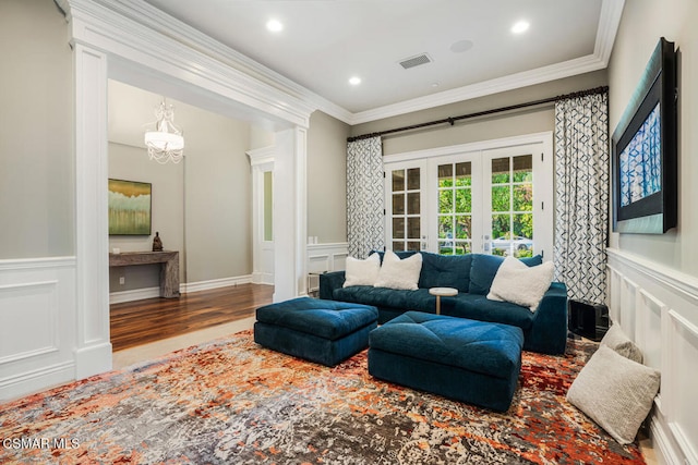 living room featuring hardwood / wood-style floors, ornamental molding, and french doors