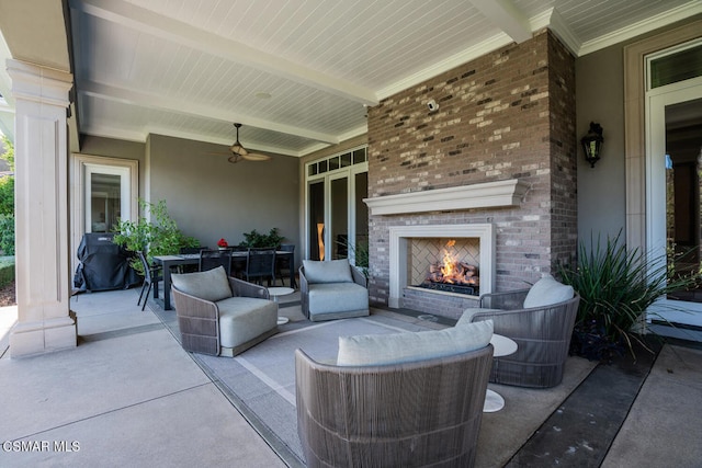 view of patio with ceiling fan, area for grilling, and an outdoor brick fireplace