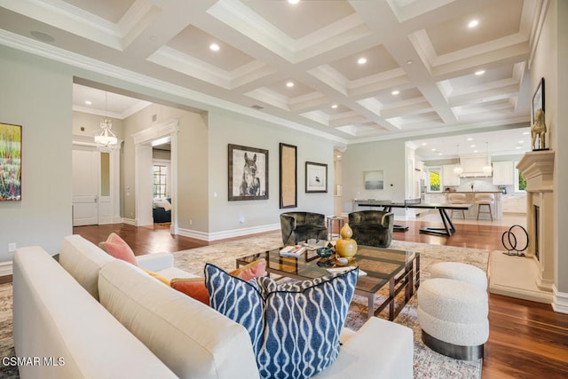 living room featuring wood-type flooring, beamed ceiling, a stone fireplace, and coffered ceiling