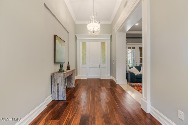 foyer entrance featuring ornamental molding, dark hardwood / wood-style flooring, and a notable chandelier