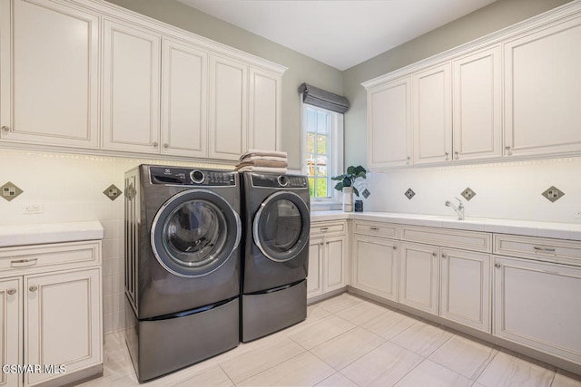 laundry room featuring washer and dryer, cabinets, light tile patterned floors, and sink