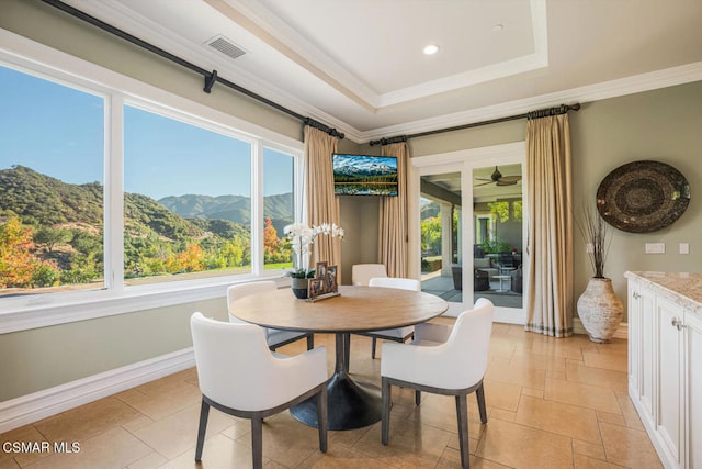 dining space with ceiling fan, crown molding, and a raised ceiling