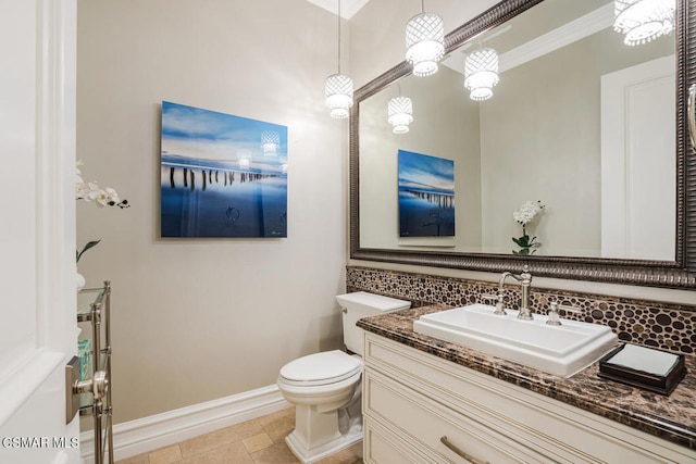 bathroom with tile patterned flooring, vanity, decorative backsplash, toilet, and ornamental molding